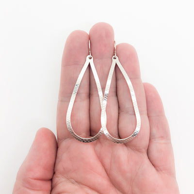 sterling silver Textured Pear Drop Earrings by Judie Raiford held in hand