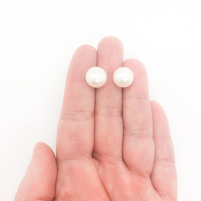 Extra Large 12mm White Pearl Stud Earrings by Judie Raiford held in hand