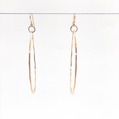 14k Gold Filled Large Hammered Hoop Earrings by Judie Raiford hanging on wire