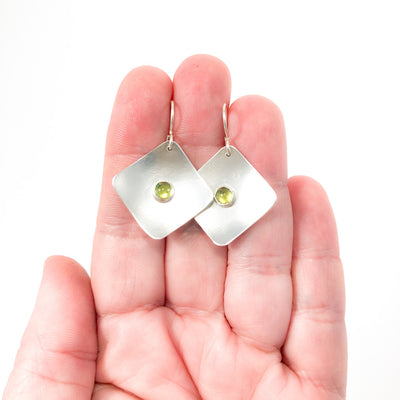 Sterling Non Stick Earrings with Peridot by Judie Raiford held in hand