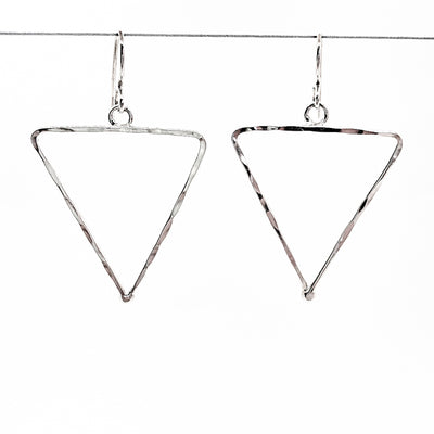 sterling silver Short Hammered Triangle Earrings by Judie Raiford hanging on wire