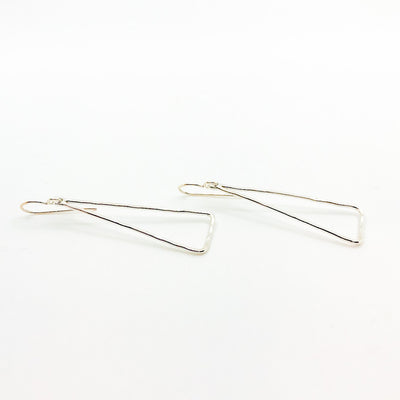 side angle view of Sterling Skinny Hammered Triangle Earrings by Judie Raiford