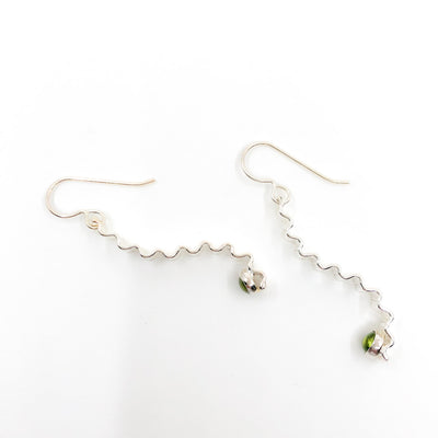 side angle view of Short Sterling Corrugated Wave Stick Ears with Peridot and french hook by Judie Raiford
