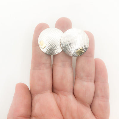 Sterling and 24k Textured Dome Earrings by Judie Raiford held in hand