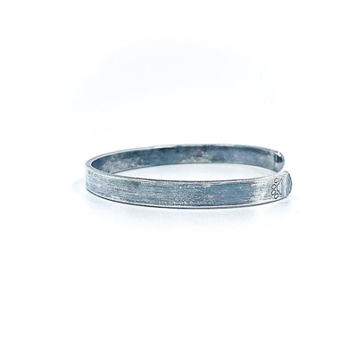 left side view of Oxidized Sterling Flat Band Cuff with Paw Print by Judie Raiford