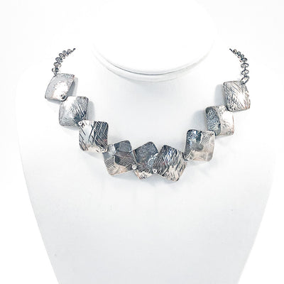 Oxidized Sterling Traveling Squares Necklace by Judie Raiford on white display mannequin