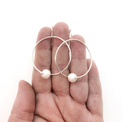 Sterling Twisted Hoop Pearl Earrings by Judie Raiford held in hand