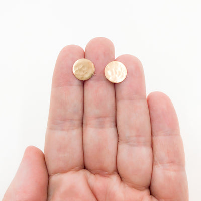 14k Gold Filled Textured Circle Stud Earrings by Judie Raiford held in hand