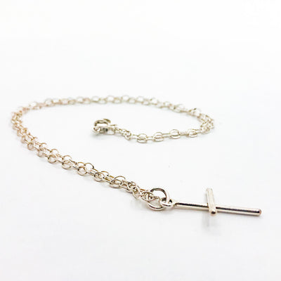 side angle view of Sterling Tiny Cross Necklace by Judie Raiford
