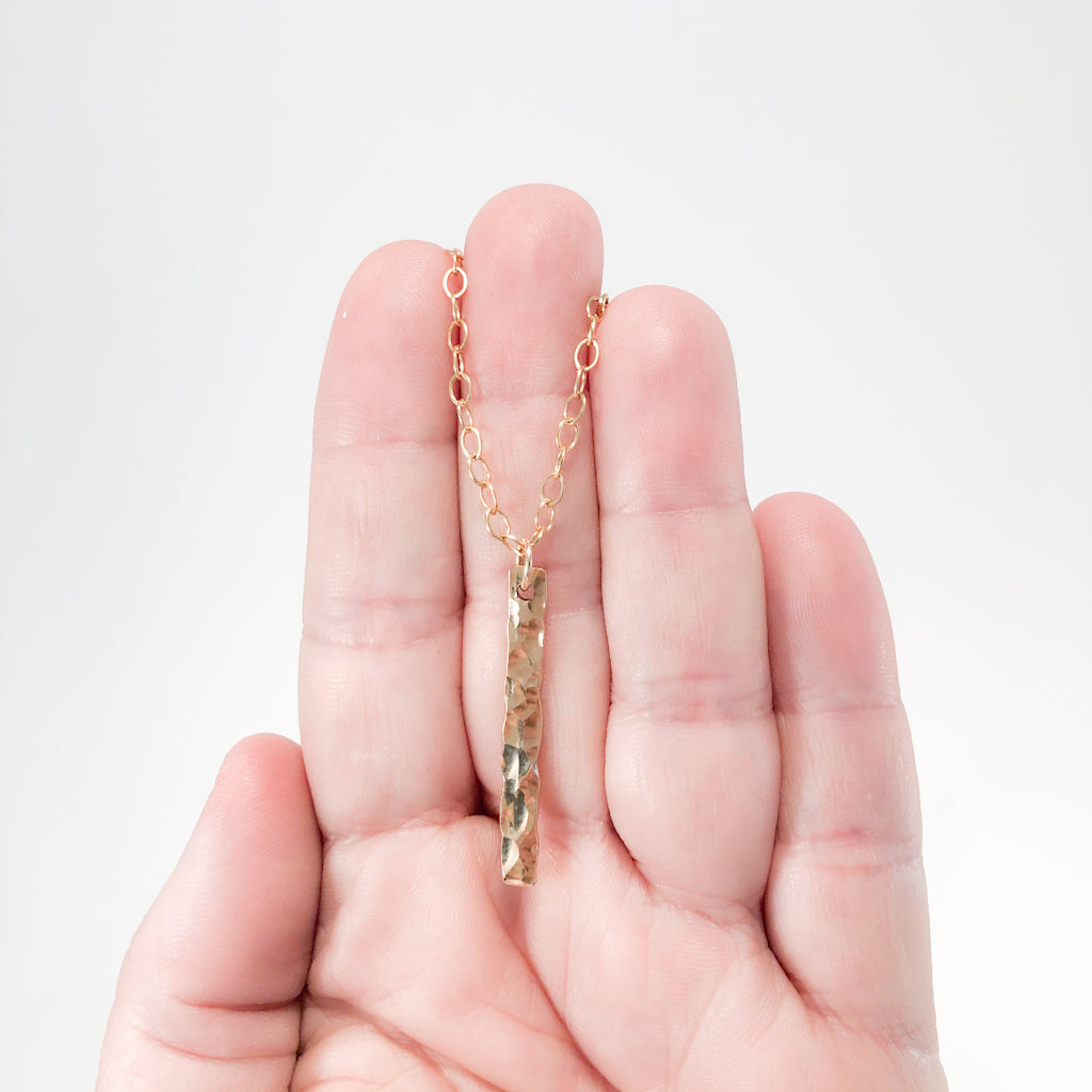 14k Gold Filled Hammered Bar Necklace by Judie Raiford held in hand