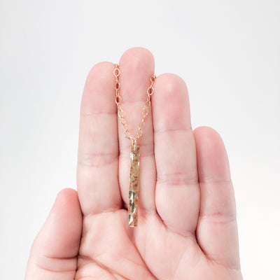 14k Gold Filled Hammered Bar Necklace by Judie Raiford held in hand