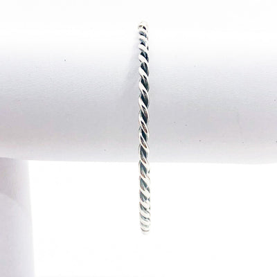Double Twist Oxidized Sterling Bangle by Judie Raiford on white jewelry display stand