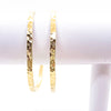 pair of 14k Gold Filled Ball Pein Hammered Bangles by Judie Raiford hanging on white bracelet display stand
