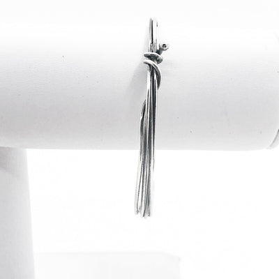 Wrapped Oxidized Sterling Bangle by Judie Raiford on white jewelry display stand