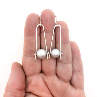 Short Tic Toc Earrings with Gray Pearls by Judie Raiford held in hand