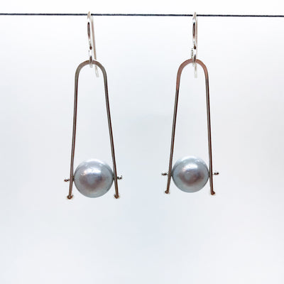 Short Tic Toc Earrings with Gray Pearls by Judie Raiford hanging on a wire