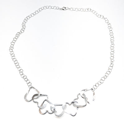 flat lay of Hammered Sterling Silver 7 Heart Necklace by Judie Raiford