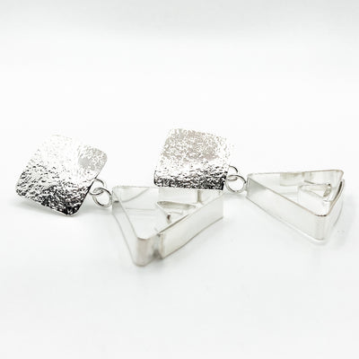 side angle view of Sterling Disc Top Teepee Earrings by Judie Raiford