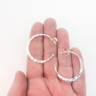 sterling silver medium Forged Hoops by Judie Raiford held in hand