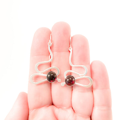 Sterling Touch of Romance Earrings with Garnet by Judie Raiford held in hand