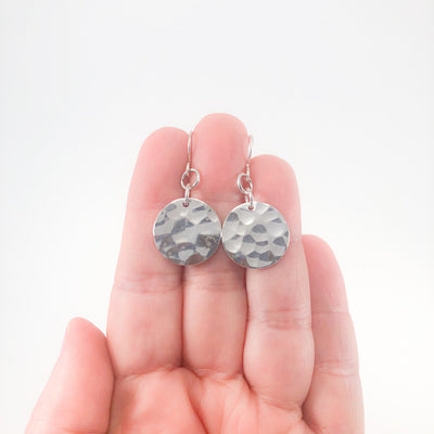 Sterling Flat Disc Ball Pein Earrings by Judie Raiford held in hand