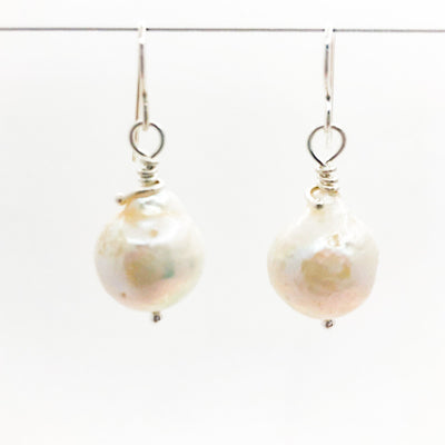 Large White Baroque Pearl Earrings by Judie Raiford hanging on wire