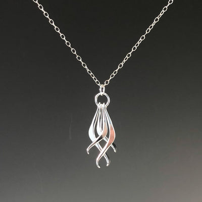 detail view of Four Dang Necklace by Judie Raiford against dark background