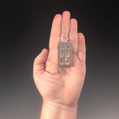 Windows of Opportunity Necklace by Ling-Yen Jones pendant held in hand