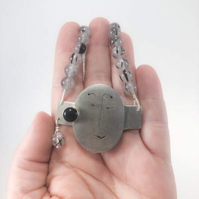 Sterling Unmentionables Necklace with Onyx and Rutilated Quartz Tourmaline by Ling-Yen Jones held in hand