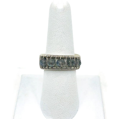 Sterling Ring with Round Faceted Labradorite Beads by Tana Acton on white ring display finger