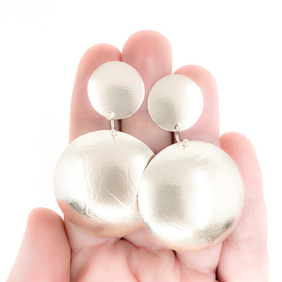Sterling Textured Double Disc Earrings by Judie Raiford held in hand