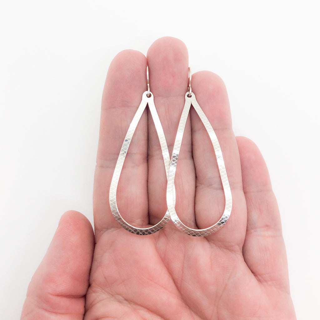 sterling silver Textured Pear Drop Earrings by Judie Raiford held in hand