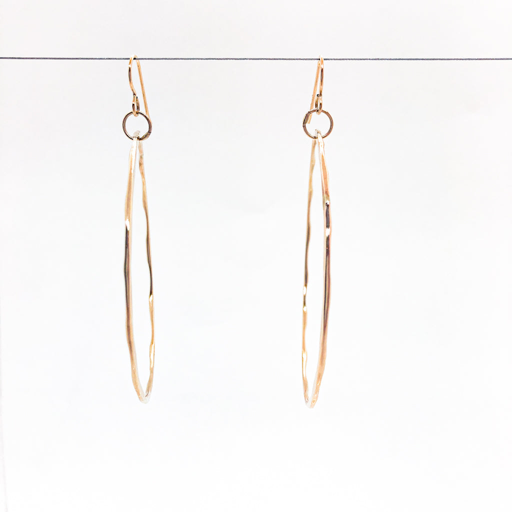 14k Gold Filled Large Hammered Hoop Earrings by Judie Raiford hanging on wire