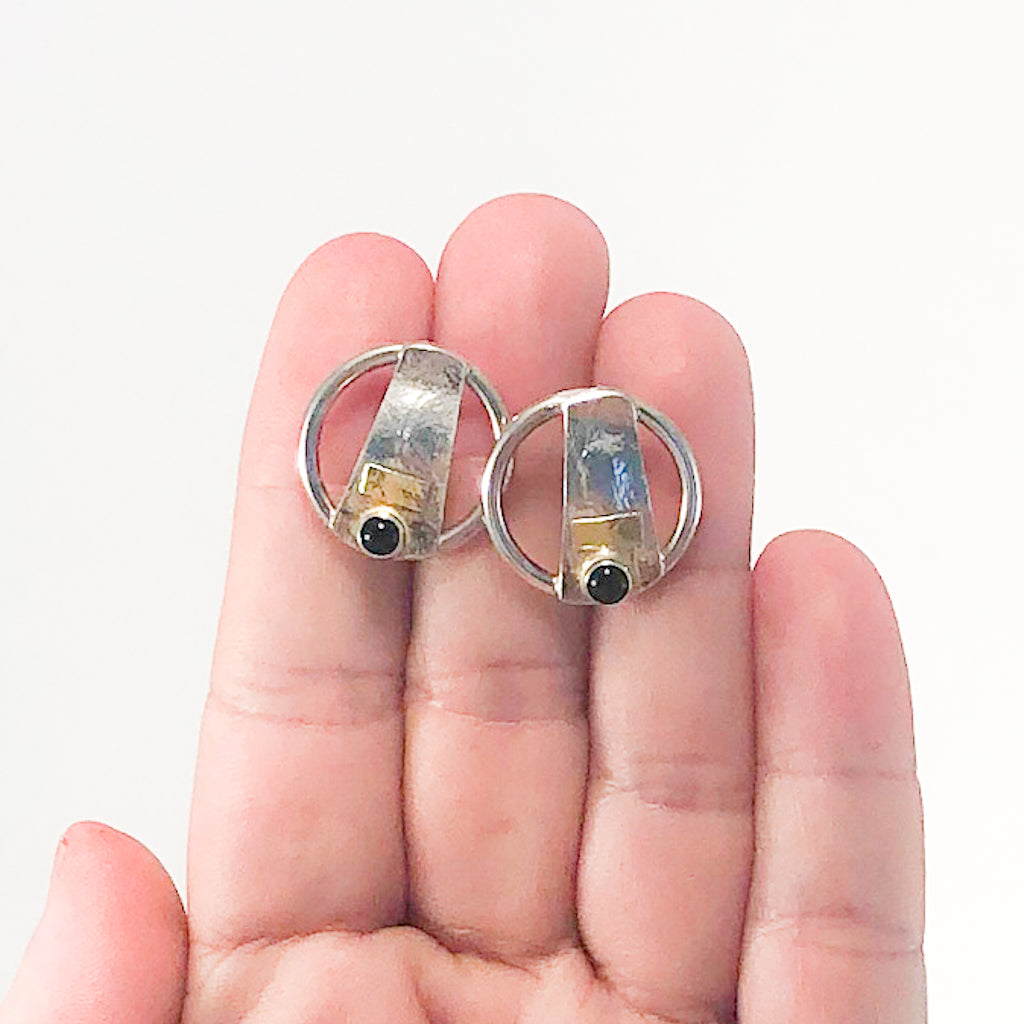 Round Lawa Earrings with Onyx by Judie Raiford held in hand