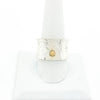 Sterling Anticlastic X Hammered Ring with 14k Ball by Judie Raiford on white ring display stand
