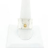 Sterling Anticlastic X Hammered Ring with 14k Ball by Judie Raiford on white ring display stand