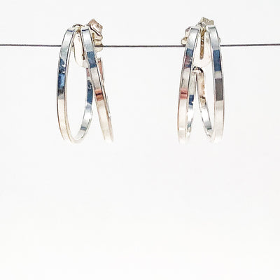 Medium Sterling Looped End Earrings by Judie Raiford hanging on wire