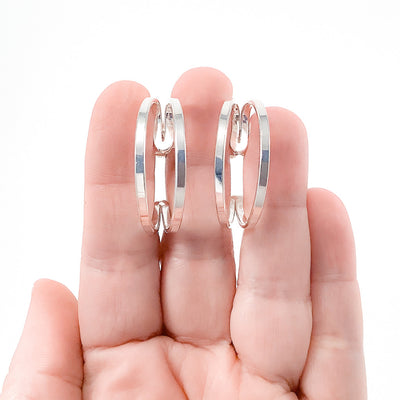 Sterling Looped End Earrings by Judie Raiford held in hand
