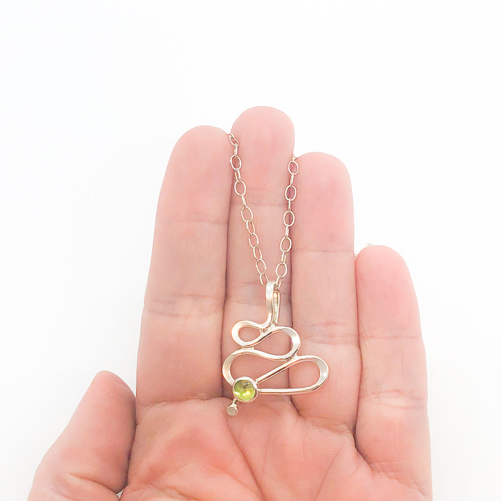 sterling silver Touch of Romance Necklace with Peridot by Judie Raiford held in hand