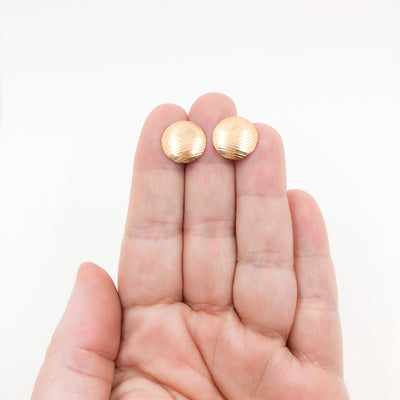 14k Gold Filled Textured Mini Disc Stud Earrings by Judie Raiford held in hand