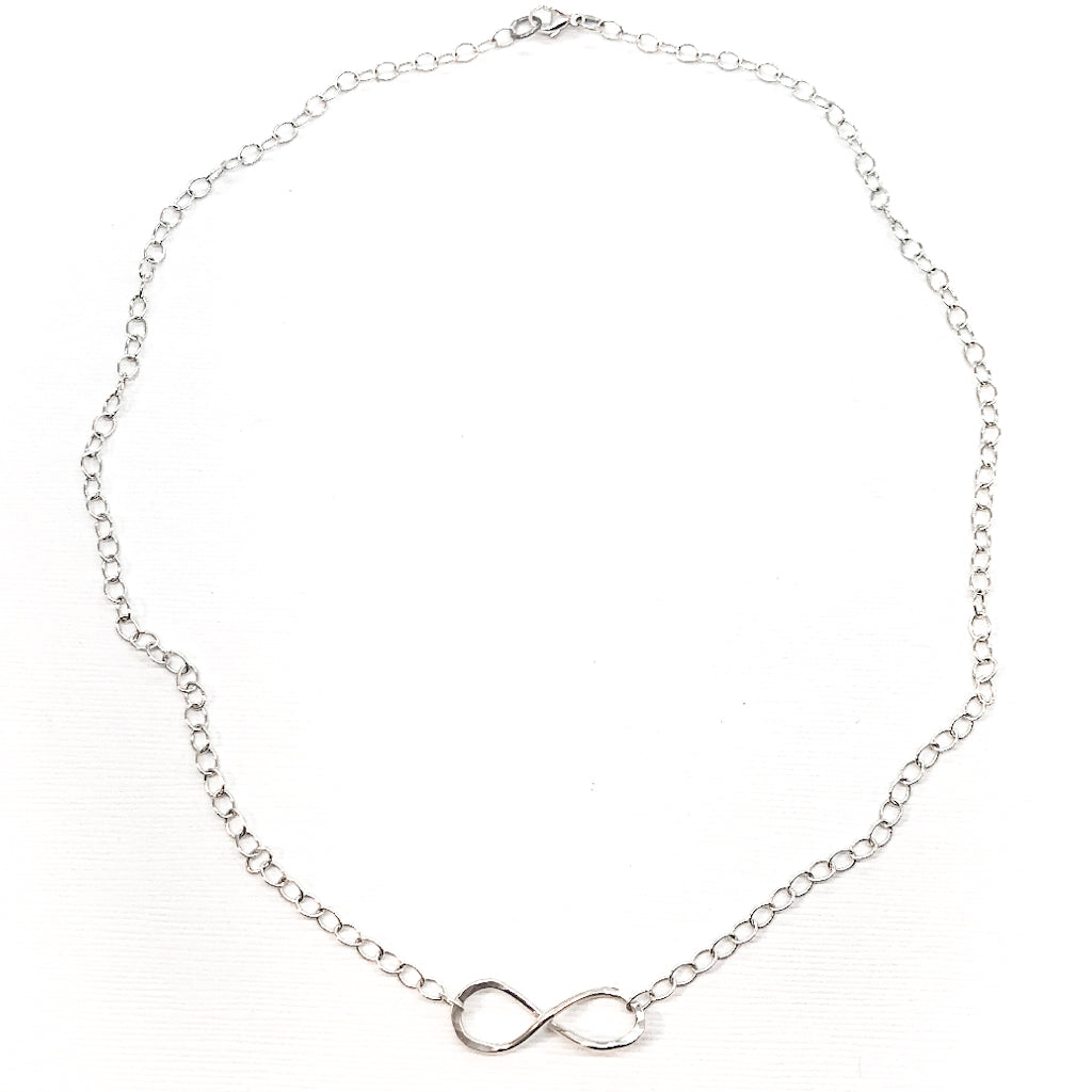 flat lay view of sterling silver Infinity Maggie Necklace by Judie Raiford