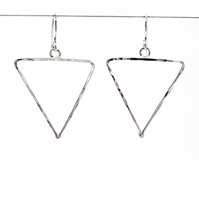 sterling silver Short Hammered Triangle Earrings by Judie Raiford hanging on wire