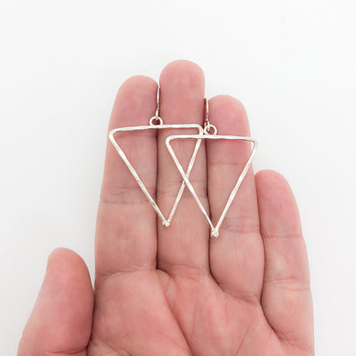 sterling silver Short Hammered Triangle Earrings by Judie Raiford held in hand
