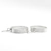 side angle view of medium sterling silver Full Moon Textured Bandage Hoop Earrings by Judie Raiford