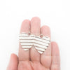 Large Sterling Silver Corrugated Heart Earrings by Judie Raiford held in hand