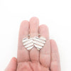 Small Sterling Silver Corrugated Heart Earrings by Judie Raiford held in hand