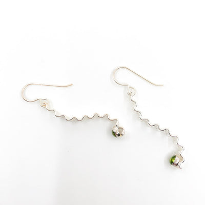 side angle view of Short Sterling Corrugated Wave Stick Ears with Peridot and french hook by Judie Raiford