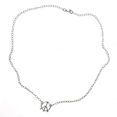 flat lay of sterling silver Tiny Peace Sign Necklace by Judie Raiford