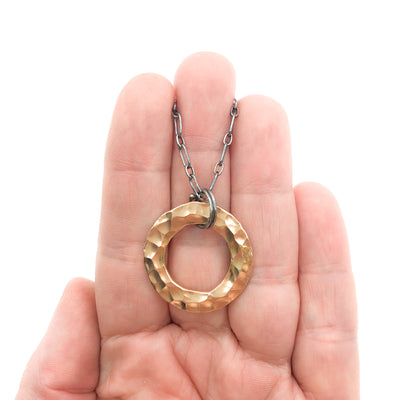 Oxidized Sterling & 14k Gold Filled Ball Pein Circle Necklace by Judie Raiford held in hand