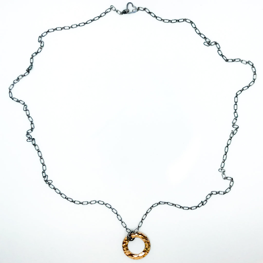 flat lay of Oxidized Sterling & 14k Gold Filled Ball Pein Circle Necklace by Judie Raiford